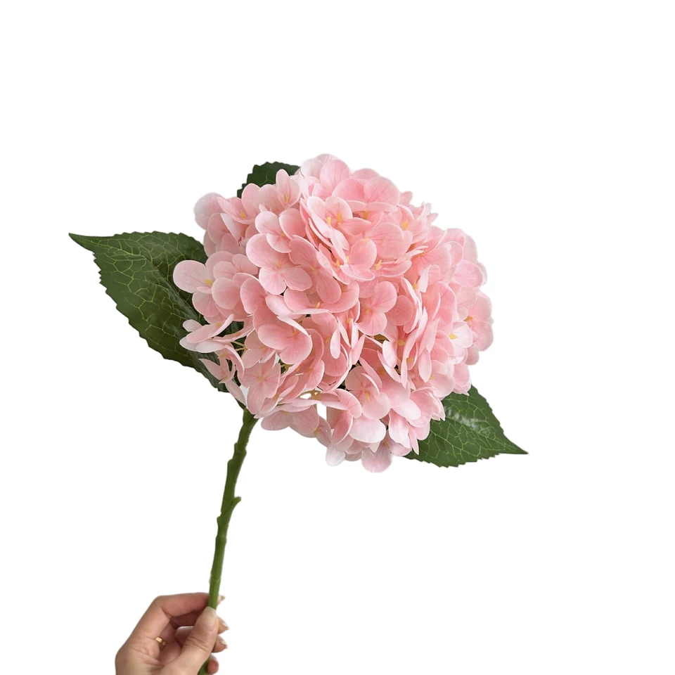 A pale pink artificial hydrangea stem with ruffled petals held upright