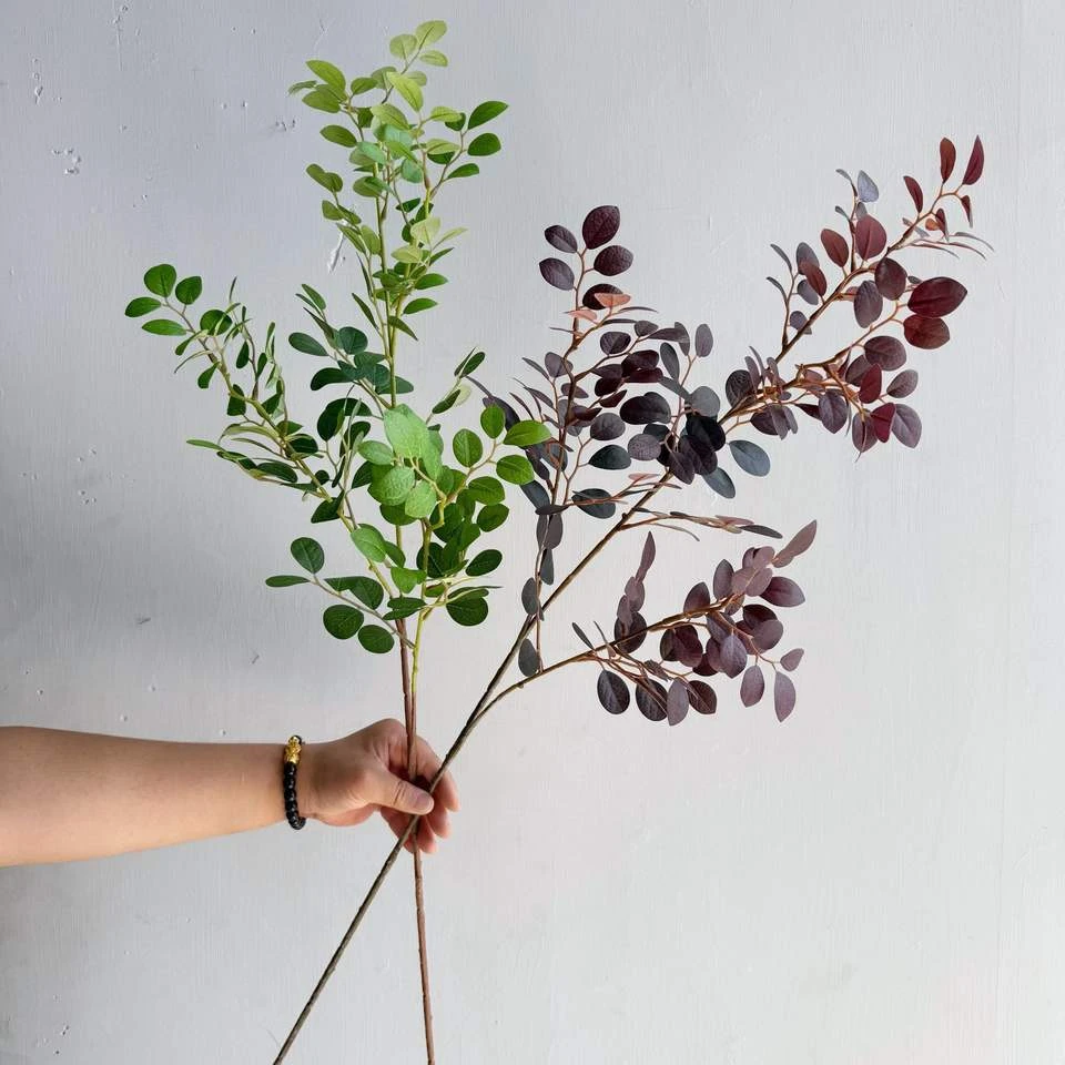 Green and burgundy artificial leaf branches held together