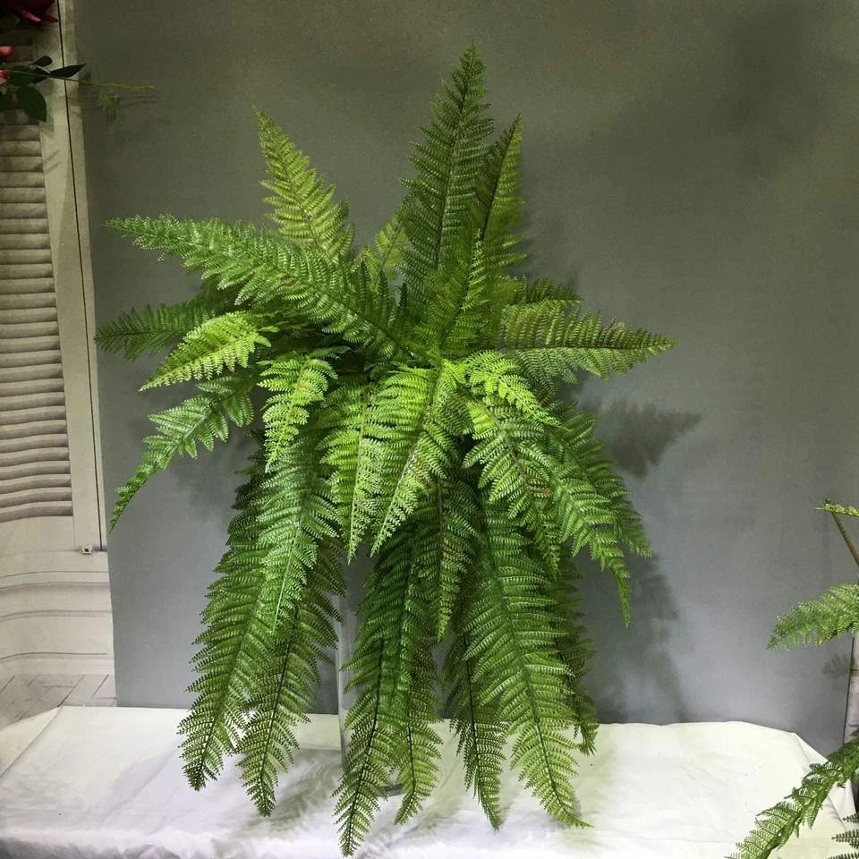 Green artificial fern foliage in a wall-mounted display
