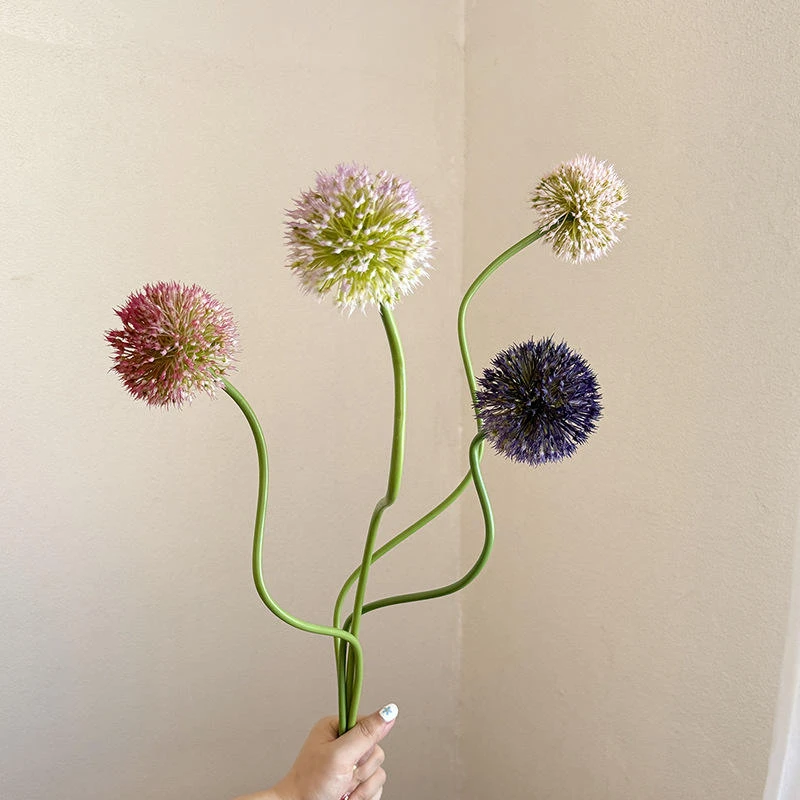Artificial spherical allium-style flowers in muted green, pink and purple on long stems