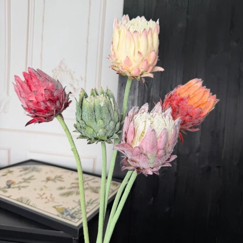 Pink and cream artificial protea stems held in a mixed group